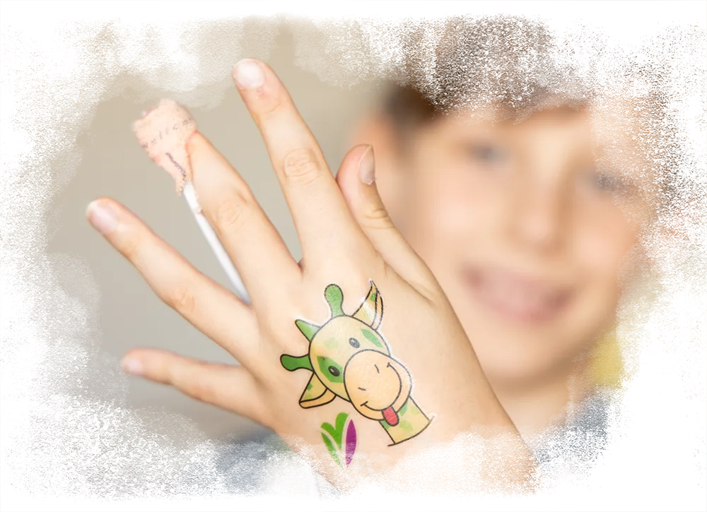 Een kind dat trots zijn hand laat zien met een vrolijke plaktattoo van Freek de Giraffe en het logo van Vrienden van het Groene Hart Ziekenhuis.